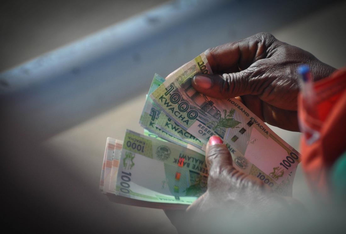 Person holds Malawian currency (Kwacha)