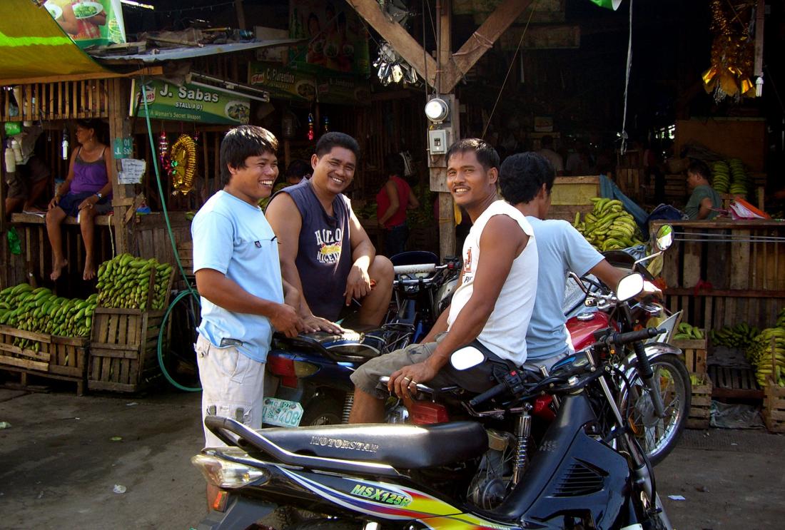 Smiling men in a market in the Philippines