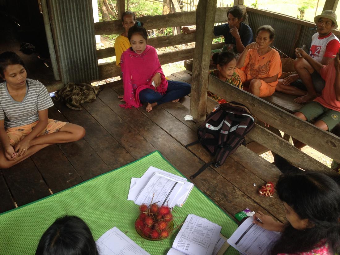 Women seated on wood porch with papers