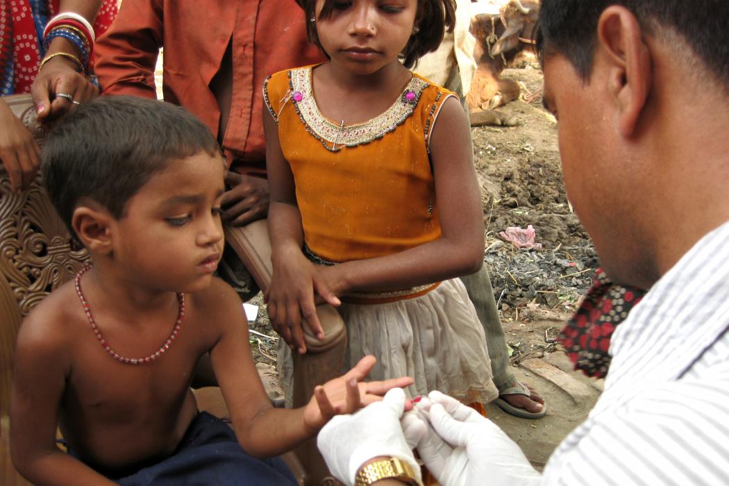 A child's blood is collected in a microcuvette