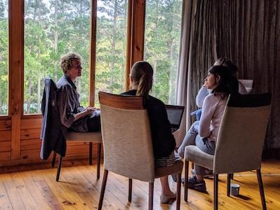 A researcher conducts an interview with three participants in a close circle