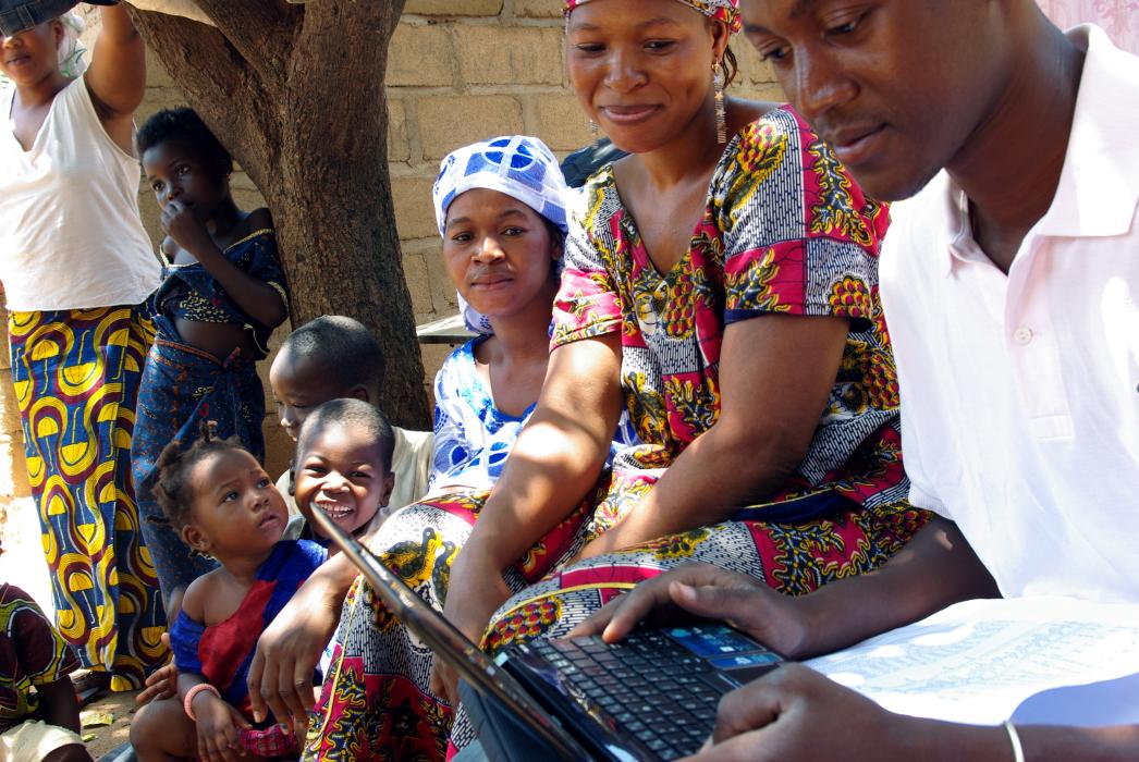 a surveyor talks to women in Mali