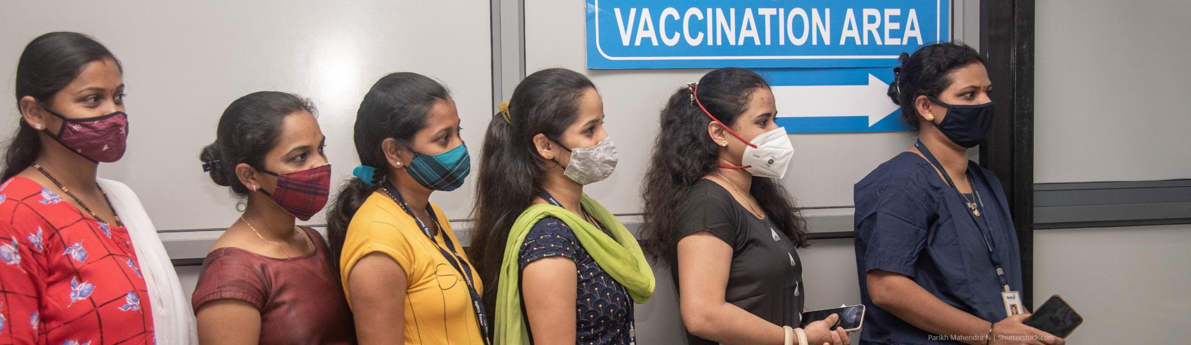 Women wait in queue to register for the Covid-19 vaccine