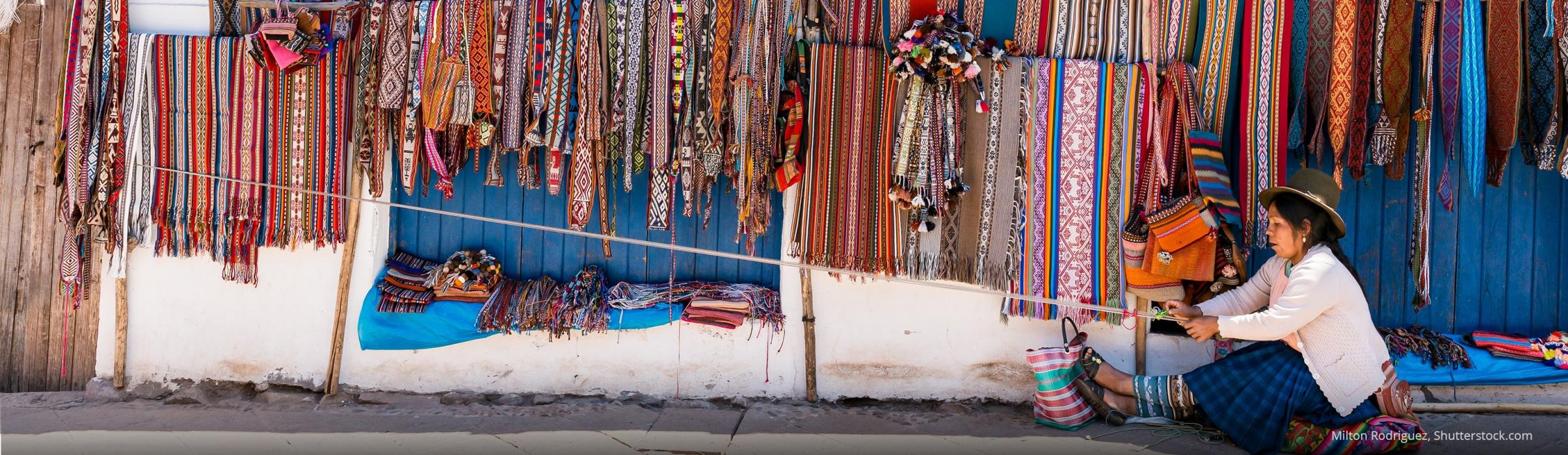 Woman weaving textile goods for her market of Pisac handicrafts in Cusco Peru
