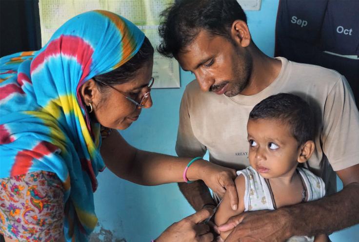 Photo: A nurse immunizes a child in India.