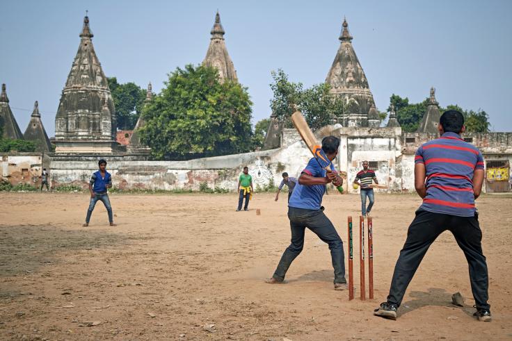 Men in India play cricket outdoors