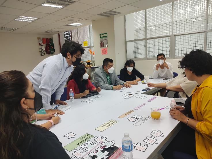 a group of people around a table in a workshop