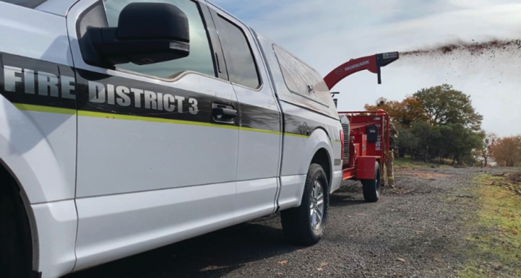 Jackson County Fire District 3’s Community Wood Chipper chipping wildland fuel off the side of the road.