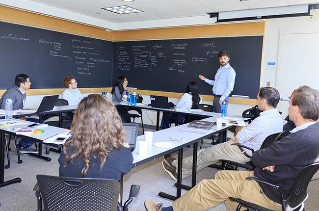 Man standing at chalkboard in front of classroom