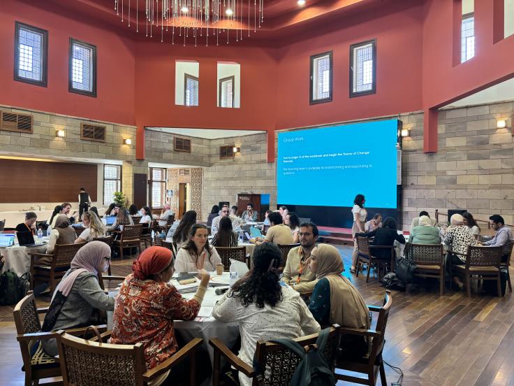 A photo of a room with people sitting around tables.