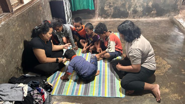 A GSED assessment session attracts a curious crowd of siblings and neighbors’ children, creating challenges for the child and assessor in maintaining focus and comfort.