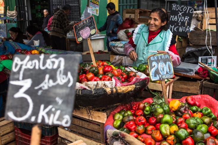 Woman smiling in front of her vegetable stand