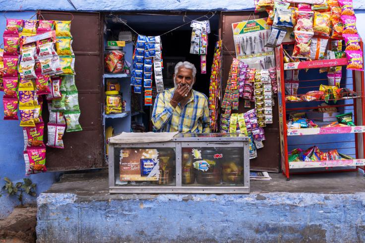 A male Indian vendor waiting at his grocery store