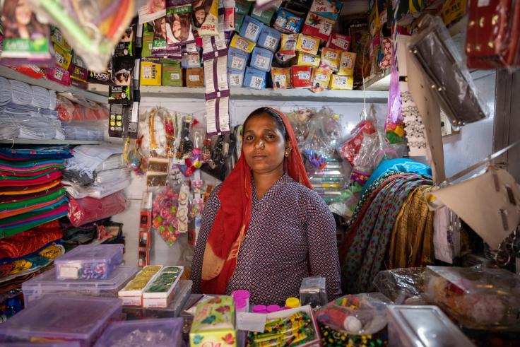 A woman standing inside her small shop
