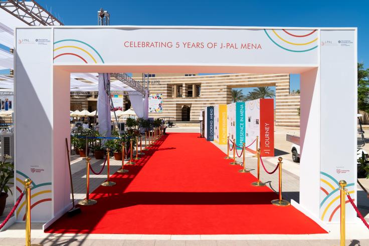 Enterance to J-PAL MENA's five year anniversary event with signage saying "Celebrating 5 years of J-PAL MENA"