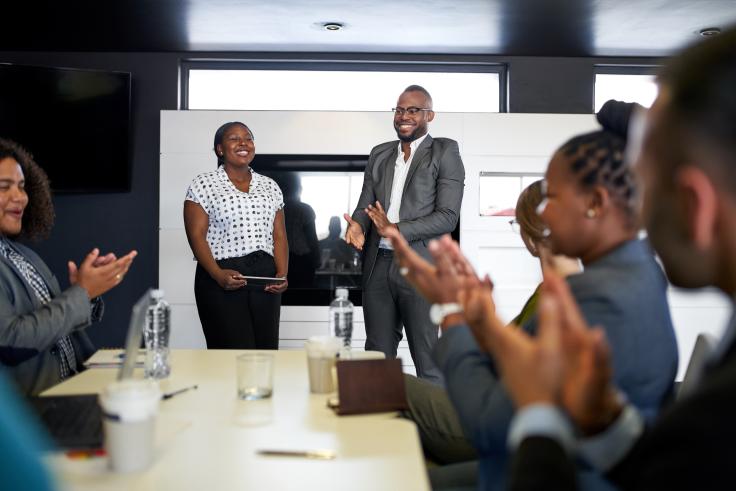 Man and woman standing in meeting presenting