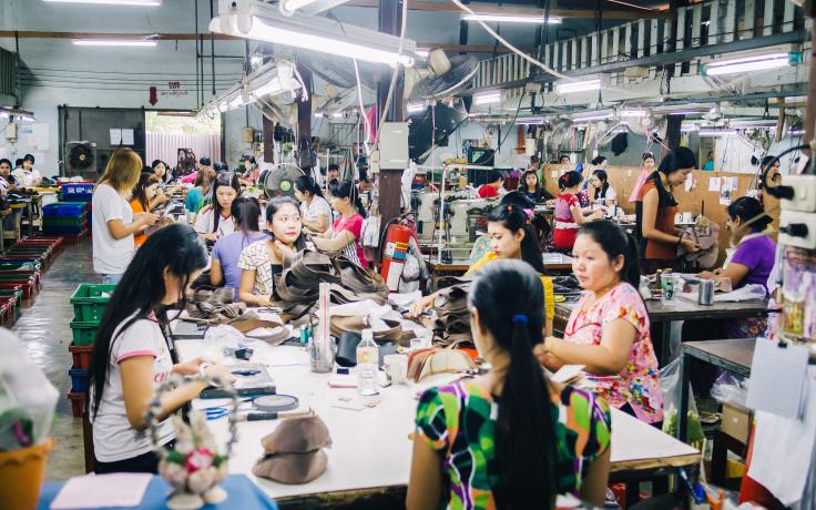 Female workers stitching shoes in a factory