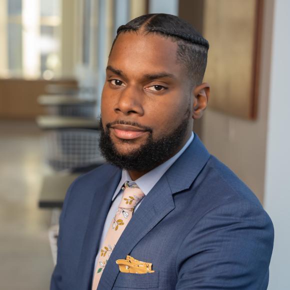 A photo of Damon Jones with a background of the University