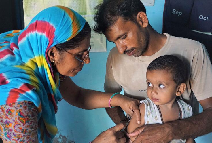 A nurse gives a child an immunization shot