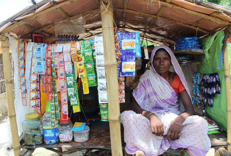 Woman sits in a stand selling snacks