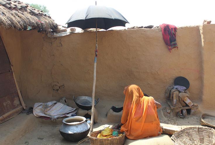 Woman sits under an umbrella