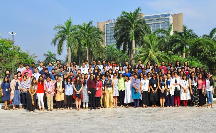 Large staff photo in front of palm trees