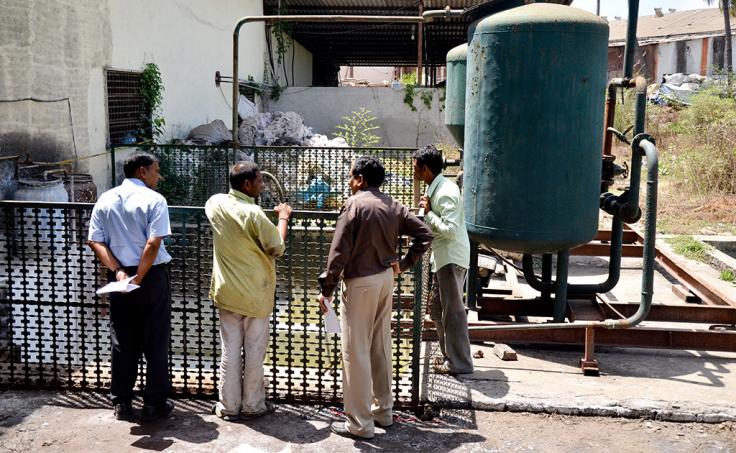 Four people inspecting a factory