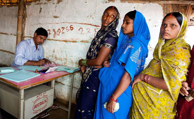 Three women wait in line at health clinic