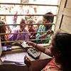 Women exchange money at a bank teller