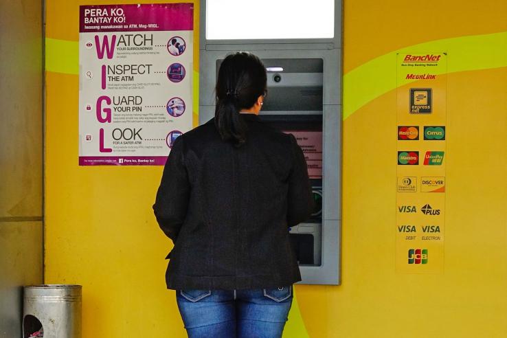 Woman using ATM in the Philippines