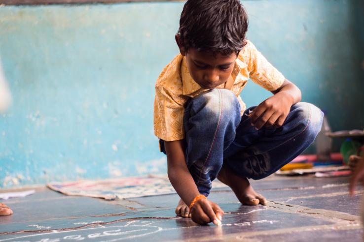 Indian boy on school room floor