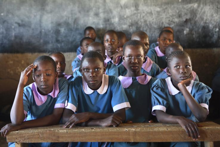 Girls in uniform sit in classroom