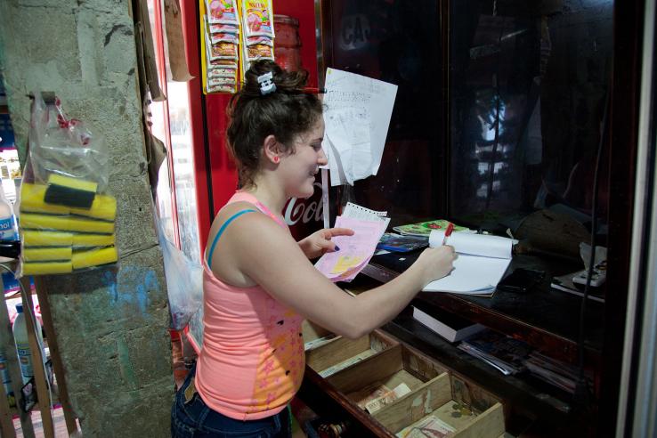 A woman completes paperwork in front of cash register