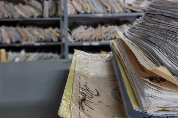 A stack of case files in a room full of files.