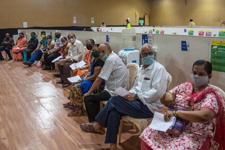 senior citizens wearing masks waiting for the Covid-19 vaccine