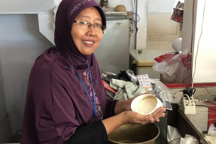 A woman holds a bowl of rice