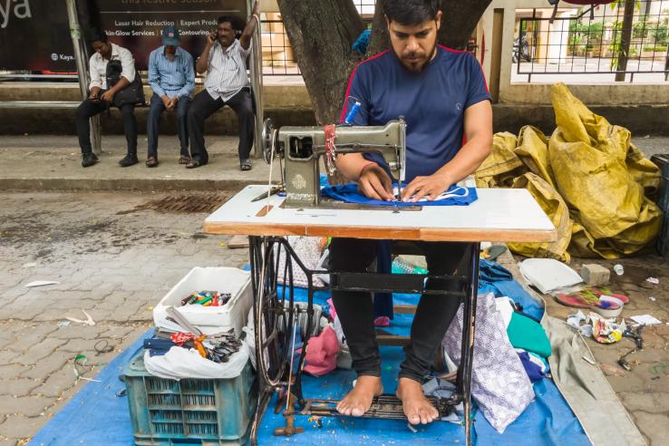 tailor working with sewing machine outdoors