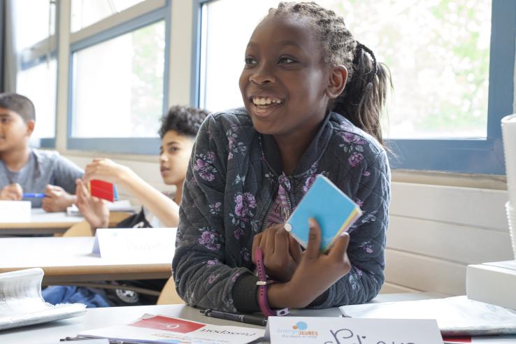 female student in class holding a book