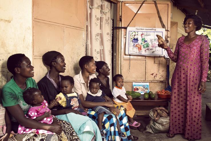 A Community Health Worker teaches nutrition to members of local households