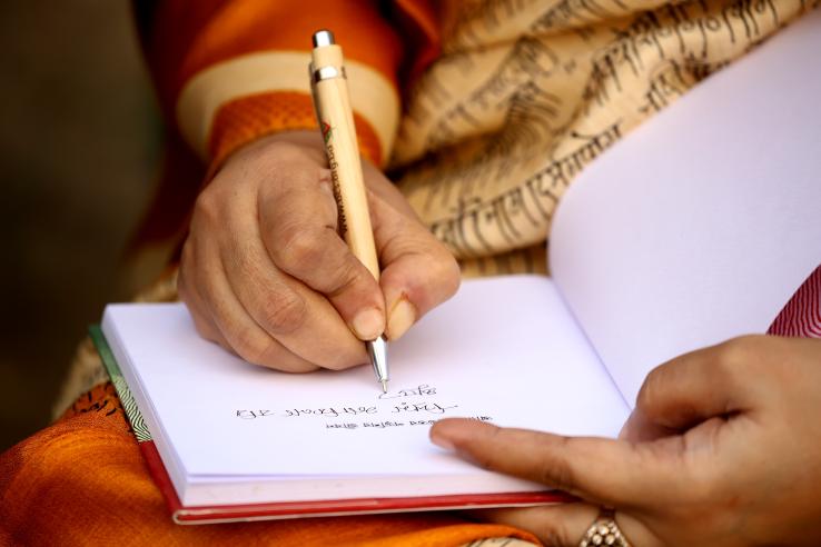 Woman writing in her journal in Bangladesh.