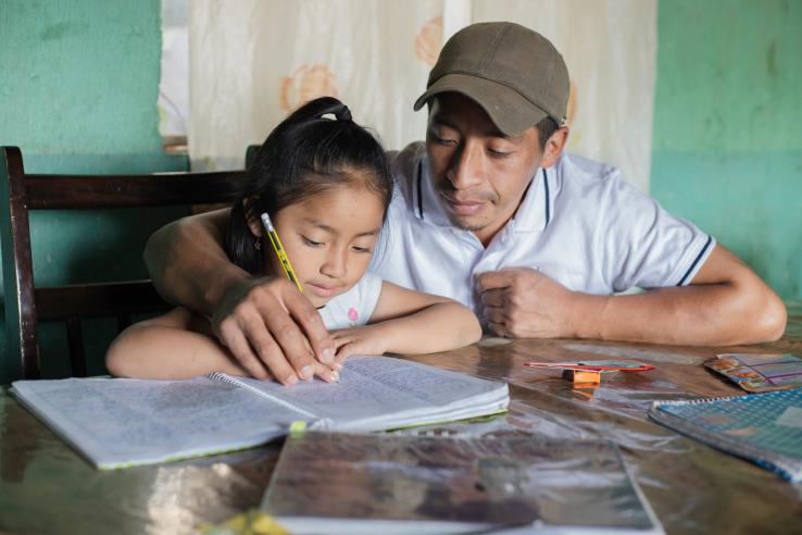 A father helping his daughter with her homework