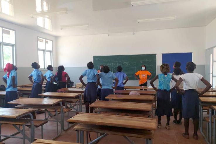 Girls and teacher standing up at a classroom in Mozambique