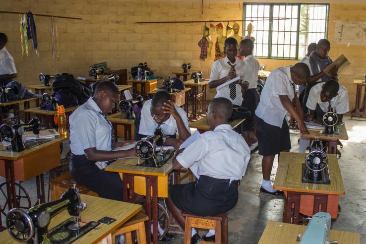 Ugandan vocational students are sewing, using the skills they gained at a vocational training institute.