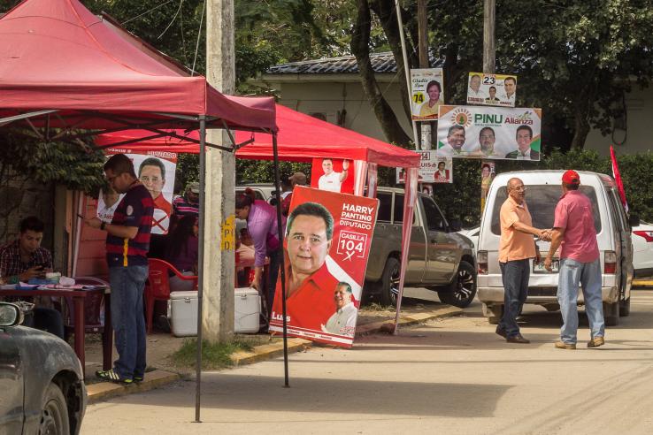 Image of voters stopping by political party booths in Honduras.