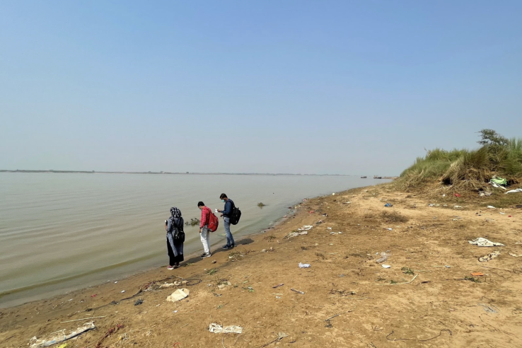 People standing at the flooded bank of the Kosi river