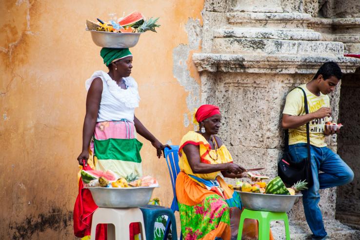 Two woman selling fruits on a sidewalk in Cartagena, Colombia