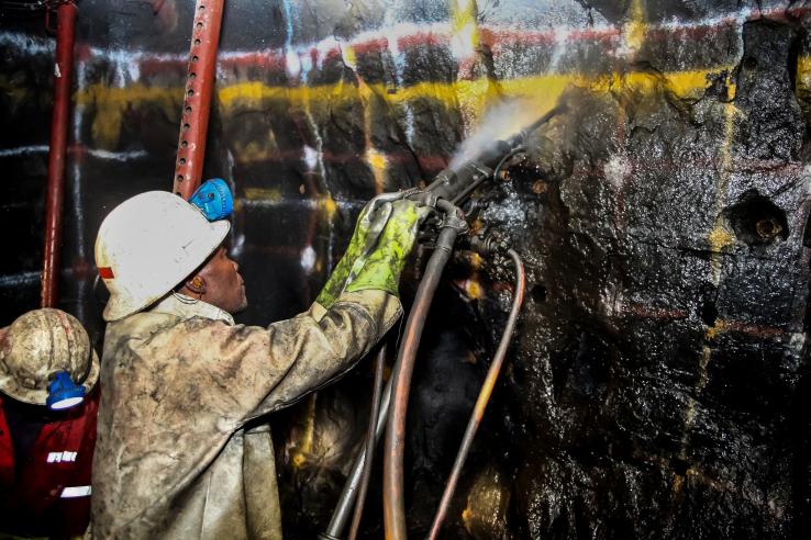 Man works in a mine in South Africa, J-PAL Africa evaluation summary