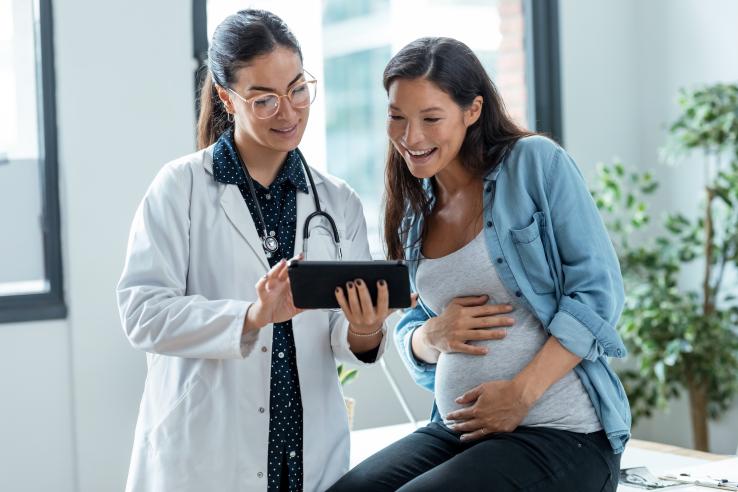 Female medical provider providing care for pregnant woman looking at screen in Argentina