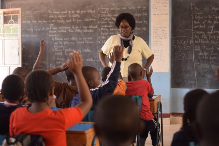 A group of children interact with their teacher in Kenya.