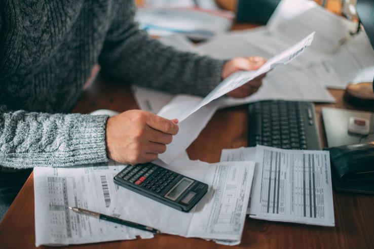 A man with long sleeve shirt ensures tax compliance by reviewing tax paperwork in Bangladesh